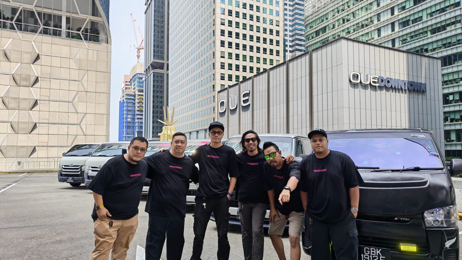 The Yayo Service team standing together in front of their delivery fleet in Singapore's CBD